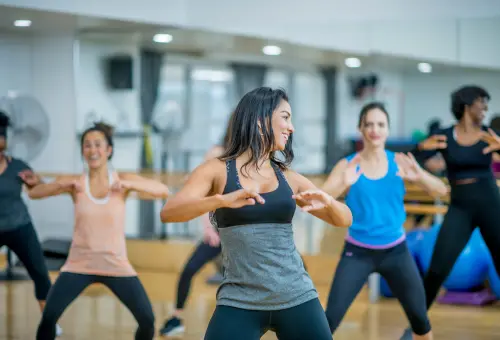  A spirited Zumba session in a mirrored studio, with participants dancing in sync to upbeat music for a fun, high-energy workout.