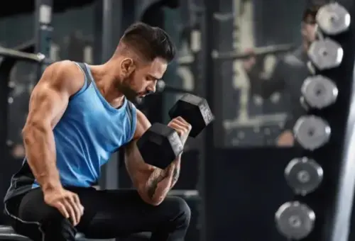 a man wearing blue half sleeve dress doing exercise with dumbbell